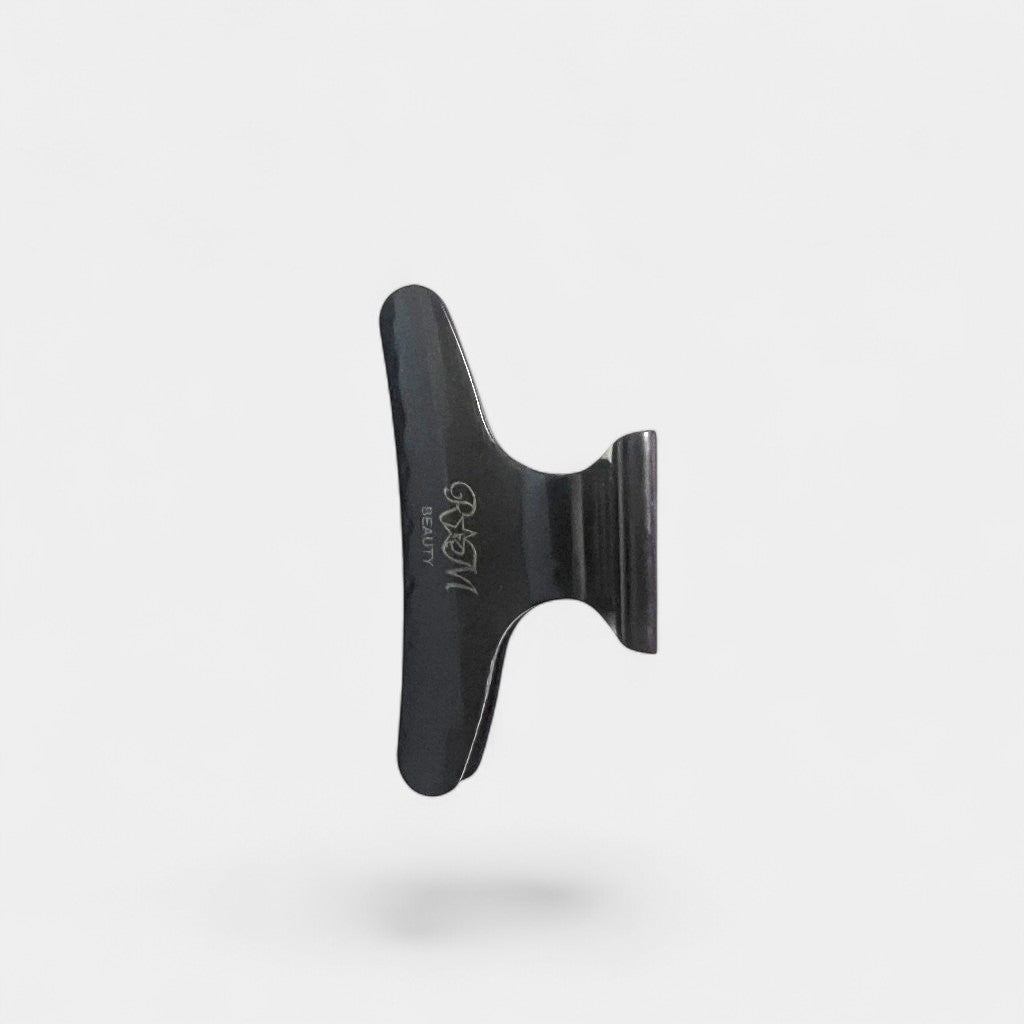 Black plastic hair clip on a gray background