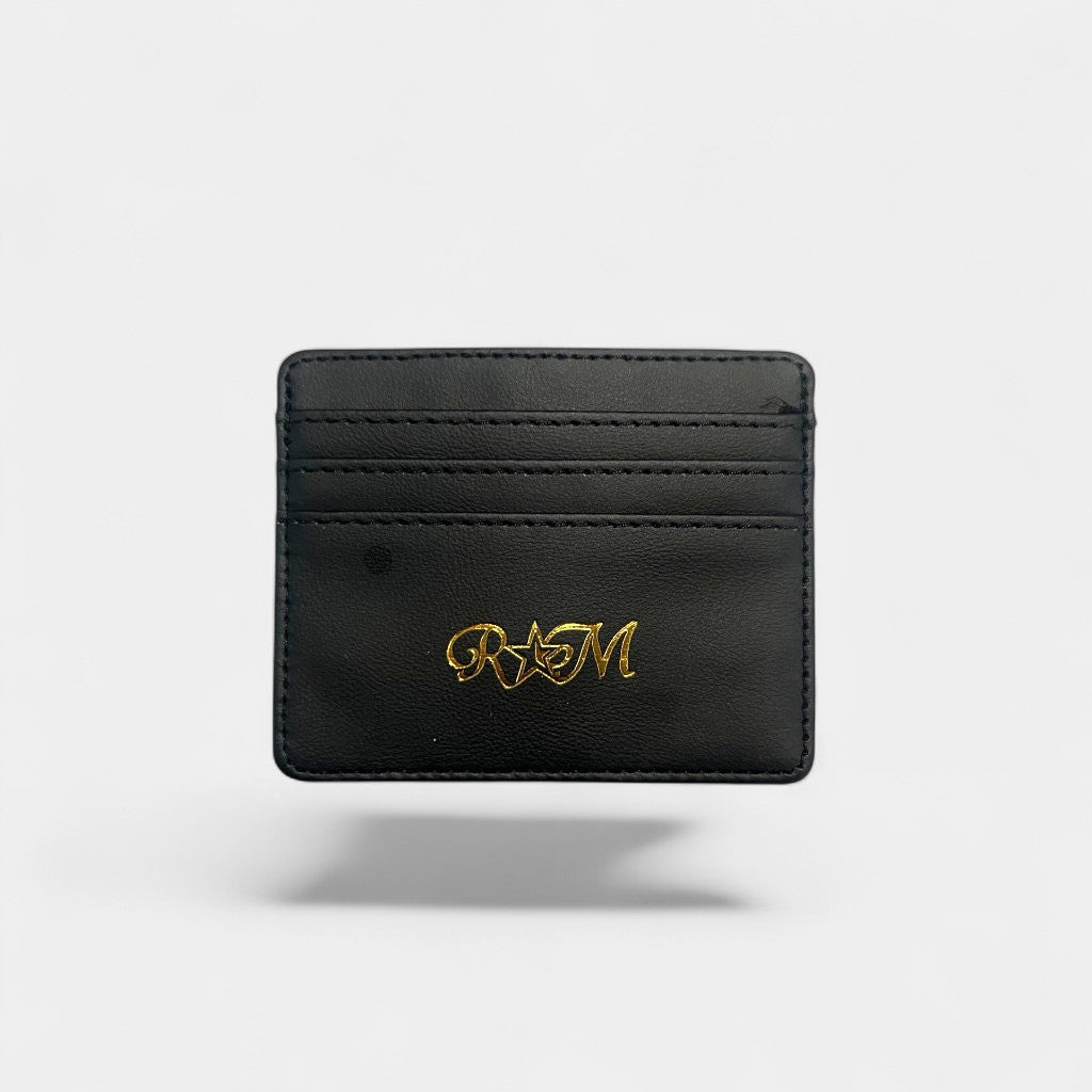 Black leather cardholder with gold logo on a grey background