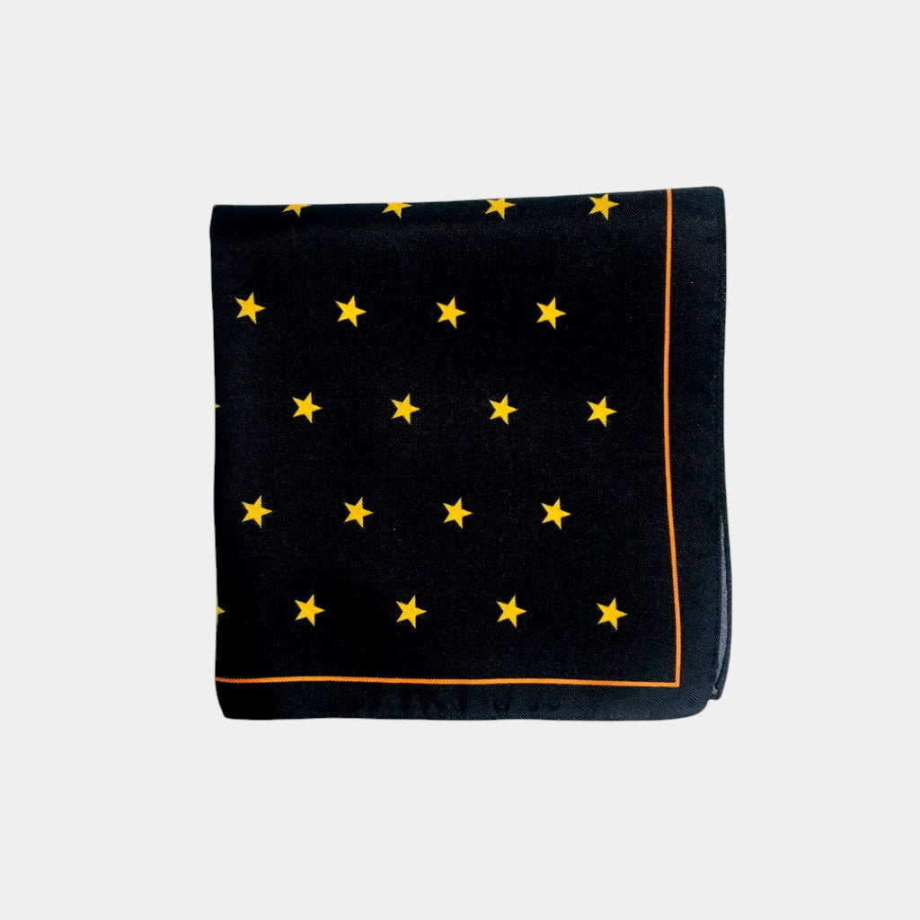 Black pocket square with yellow star pattern on a light gray background