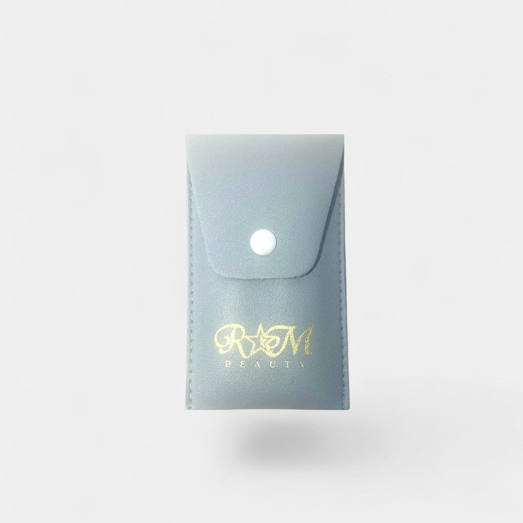 Small light blue pouch with 'R&M Beauty' logo on a gray  background